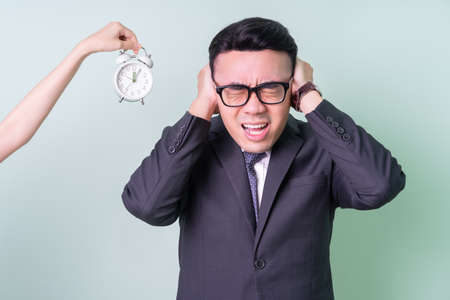 Young Asian businessman posing on green background