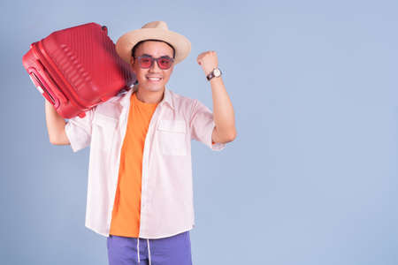 Portrait of young Asian man wearing summer clothing on blue backgroundの写真素材