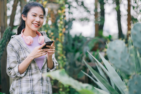 Young Asian woman drinking tea in the gardenの写真素材