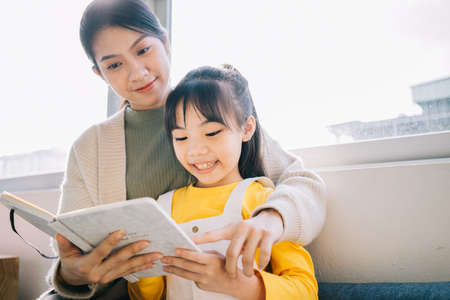 Portrait of Asian mother and daughter at homeの写真素材