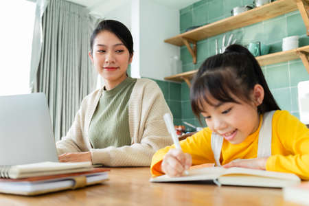 Asian Mother and daughter studying together at homeの写真素材