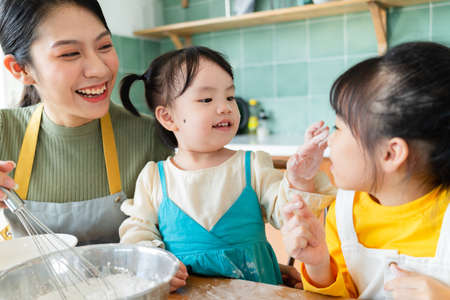Mother and daughter make cakes together.