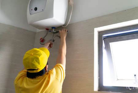 Repairmen are repairing and cleaning water heaters periodicallyの写真素材