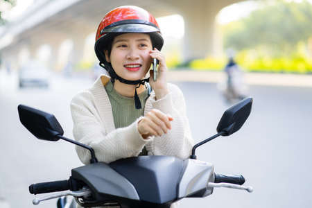 Beautiful Asian girl is listening to music by the lakeの写真素材
