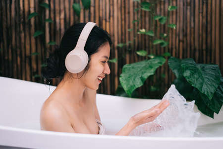 Beautiful young asian woman relaxing in the bathの写真素材