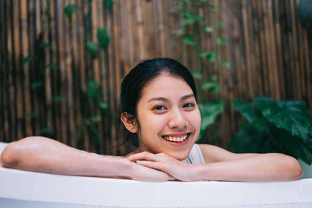 Beautiful young Asian woman wearing cucumber maskの写真素材
