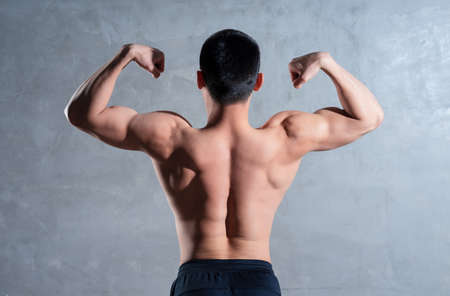 Muscular Asian man posing on gray background