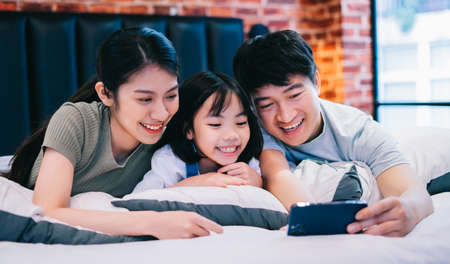 Young Asian family on the bedの写真素材