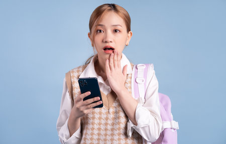 Young Asian woman holding shopping bag on pink backgroundの写真素材