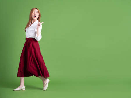 Young Asian woman holding shopping bag on pink backgroundの写真素材