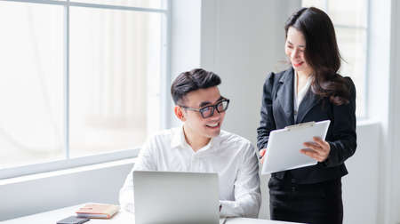 Two Asian businesspeople working at office