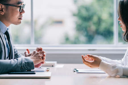 Two Asian businesspeople working at officeの写真素材