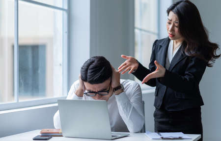 Two Asian businesspeople working at officeの写真素材