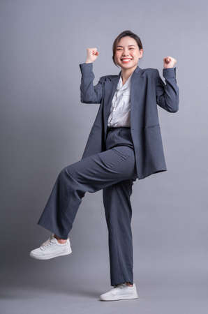 Young Asian waitress standing on pink backgroundの写真素材