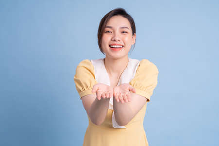 Beautiful young Asian woman dancing on pink backgroundの写真素材