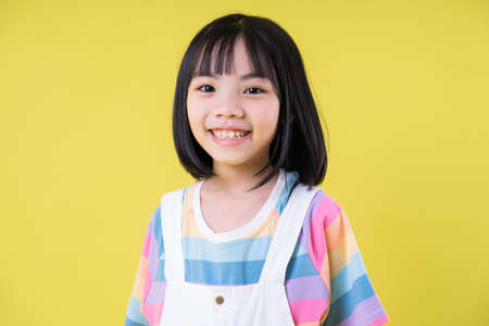 Full length image of Asian child posing on yellow backgroundの写真素材
