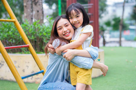 Asian mother and daughter playing together at parkの写真素材