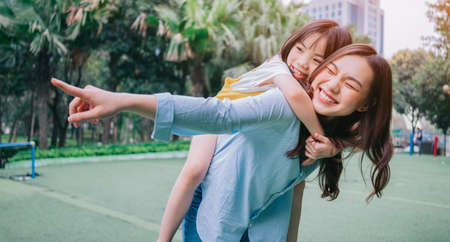 Asian mother and daughter playing together at parkの写真素材