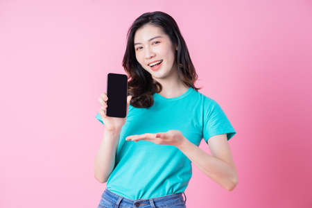 Full length image of young Asian woman wearing red dress on blue background