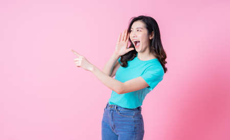 Image of young Asian business woman using smartphone on pink background