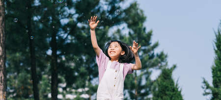 Image of Asian little girl lying on the grass at parkの写真素材