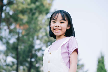 Image of Asian little girl lying on the grass at parkの写真素材