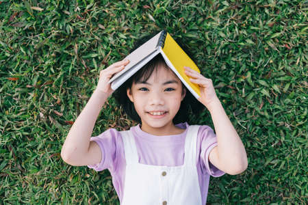 Image of Asian little girl puts used plastic bottles in the trashの写真素材
