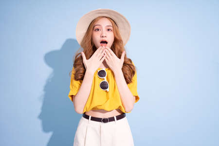 Portrait of young Asian girl on blue background, summer vacation conceptの写真素材