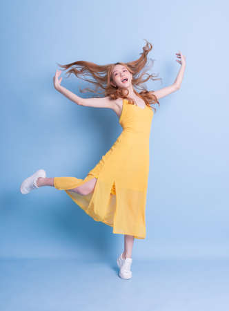 Image of young Asian girl holding swimming float on blue background, summer vacation conceptの写真素材