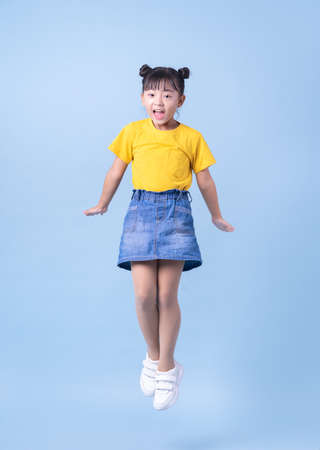Image of Asian child wearing doctor uniform on blue backgroundの写真素材