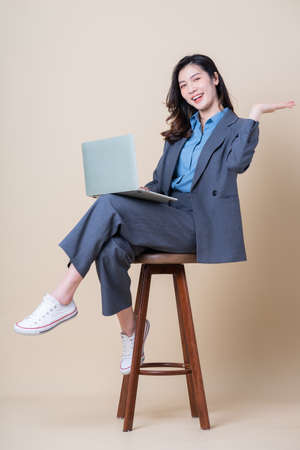 Young Asian woman using smartphone on pink backgroundの写真素材