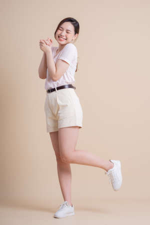 Portrait of young Asian girl posing on backgroundの写真素材