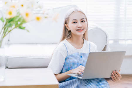 Young Asian girl using smartphone at homeの写真素材