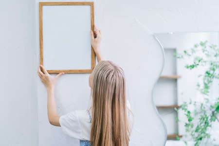 Young Asian woman spraying perfume in front of mirror