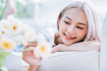 Young Asian woman spraying perfume in front of mirrorの写真素材