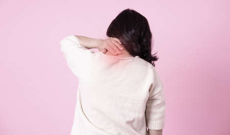 Image of middle aged Asian woman eating salad on blue backgroundの写真素材