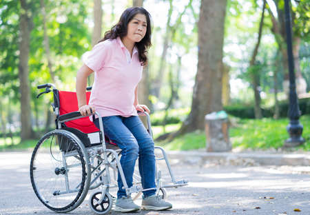 Image of middle-age Asian woman sitting on wheelchairの写真素材