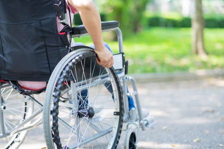 Image of middle-age Asian woman sitting on wheelchair