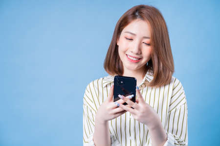 Portrait of young Asian woman sitting on couchの写真素材