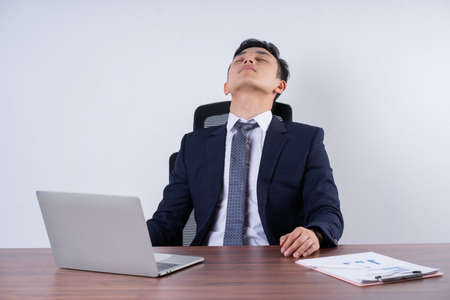 Portrait of young Asian man wearing pink suit posing on backgroundの写真素材