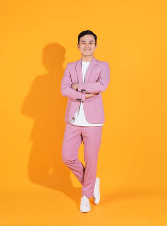 Image of young Asian man holding bank card, atm card on backgroundの写真素材