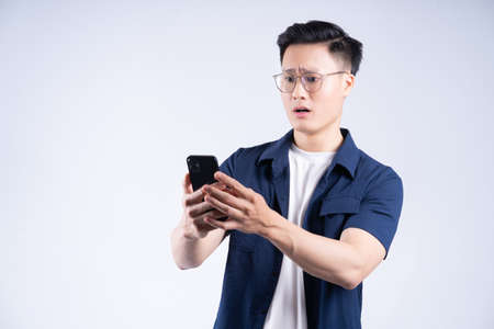 Young Asian man using laptop on white background