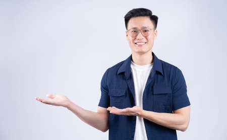 Young Asian man using laptop on white backgroundの写真素材