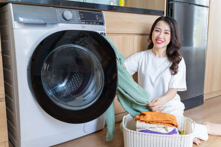 Image of young Asian woman with fridgeの写真素材