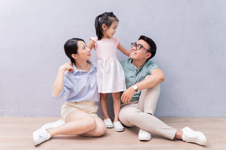 Young Asian family sitting on the floorの写真素材