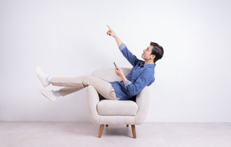 Young Asian man holding dumbbell on backgroundの写真素材
