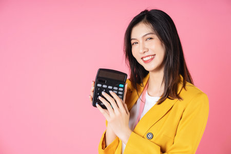 Image of young Asian businesswoman using calculatorの写真素材