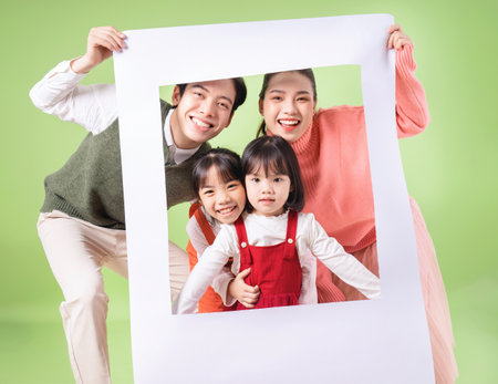 Image of young Asian family on background