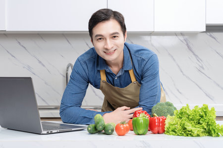 Photo of young Asian man learning cookingの写真素材