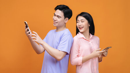 Young Asian couple using smartphone on background